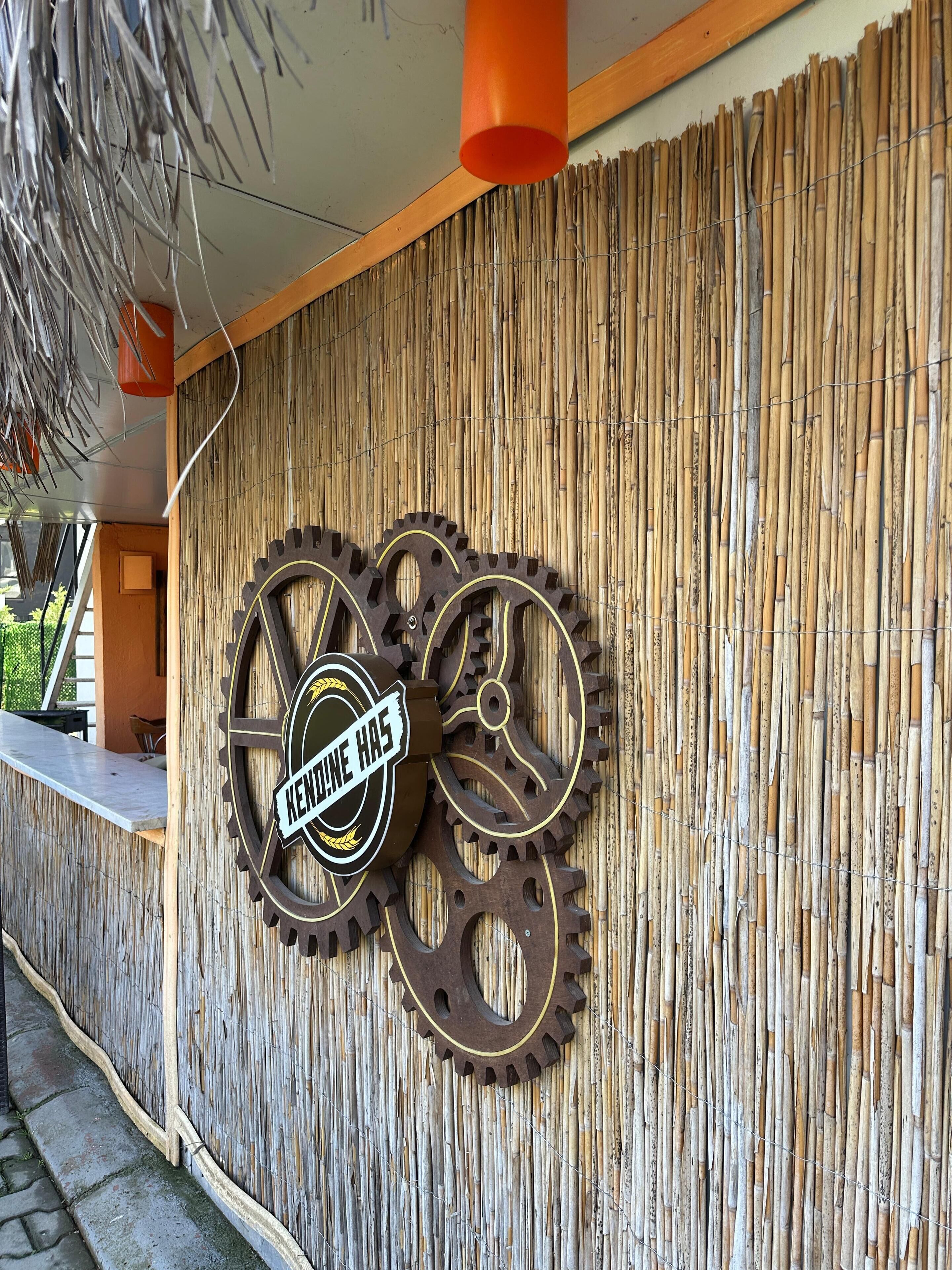 A wall with two large gears and a sign that reads "KENNIE HAS".