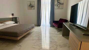 Una habitación de hotel con cama, televisión, escritorio y silla.