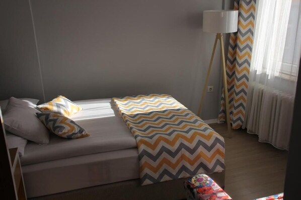 A bedroom with a bed, pillows, a bedside lamp, and curtains. - Hotel Kestanbol (Çanakkale)