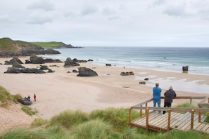 A beach with rocky outcrops and a wooden viewing platform. - Durness Youth Hostel (Durness)