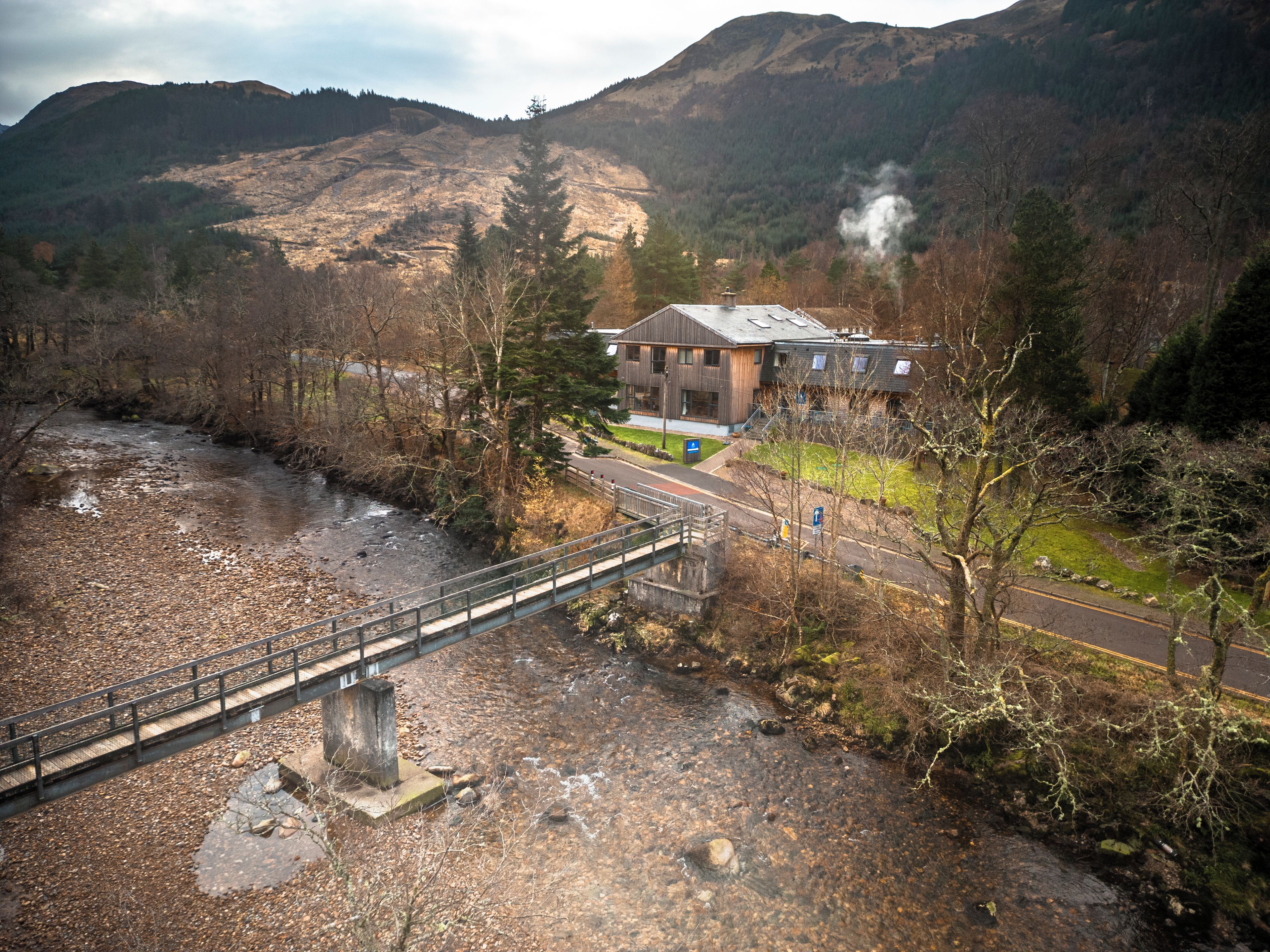 A bridge over a river with a building in the background.