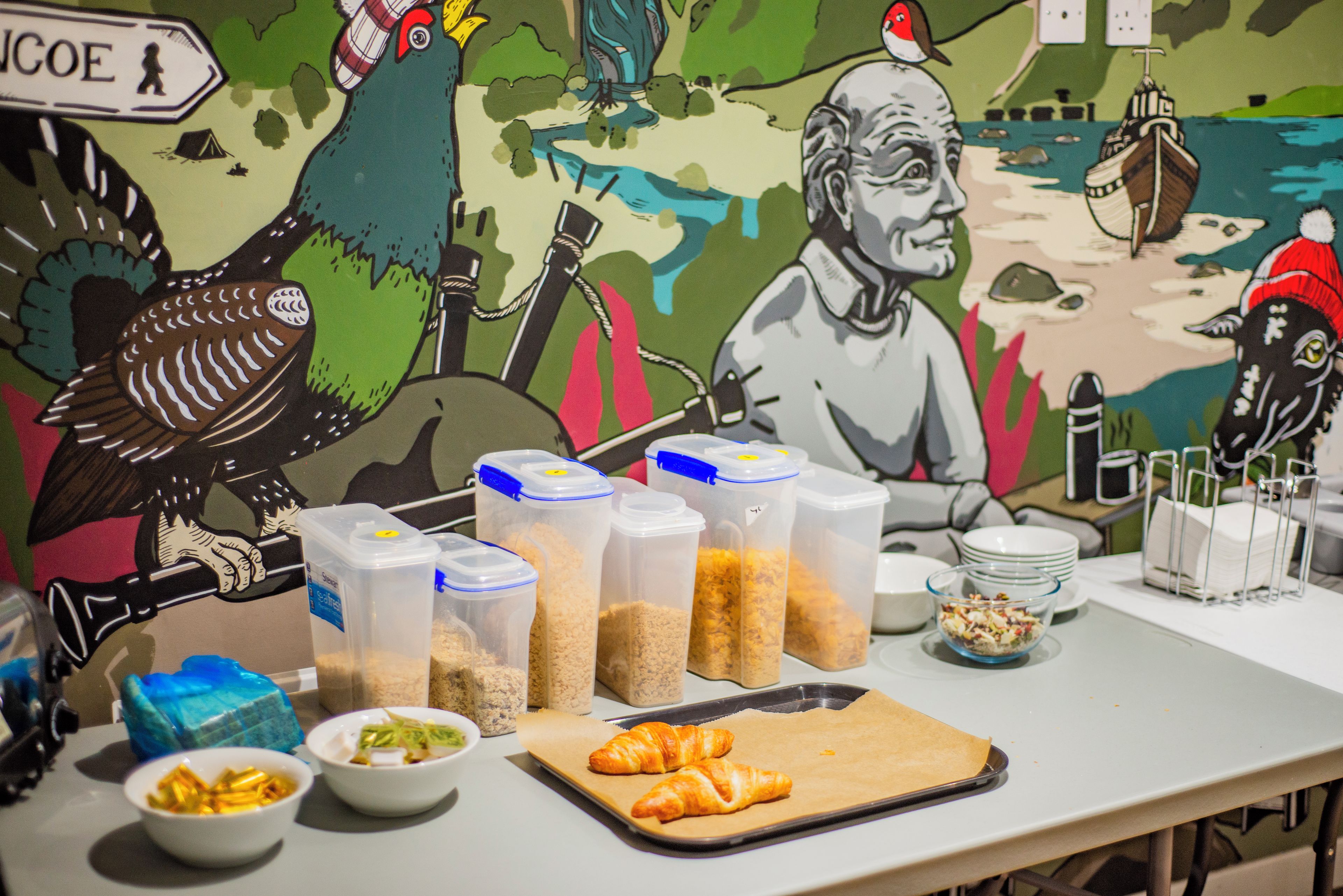 Une table avec des aliments, des récipients et un tableau en arrière-plan.