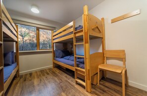 A bunk bed room with a window, wooden floor, and a chair. - Glen Nevis Youth Hostel (Fort William)
