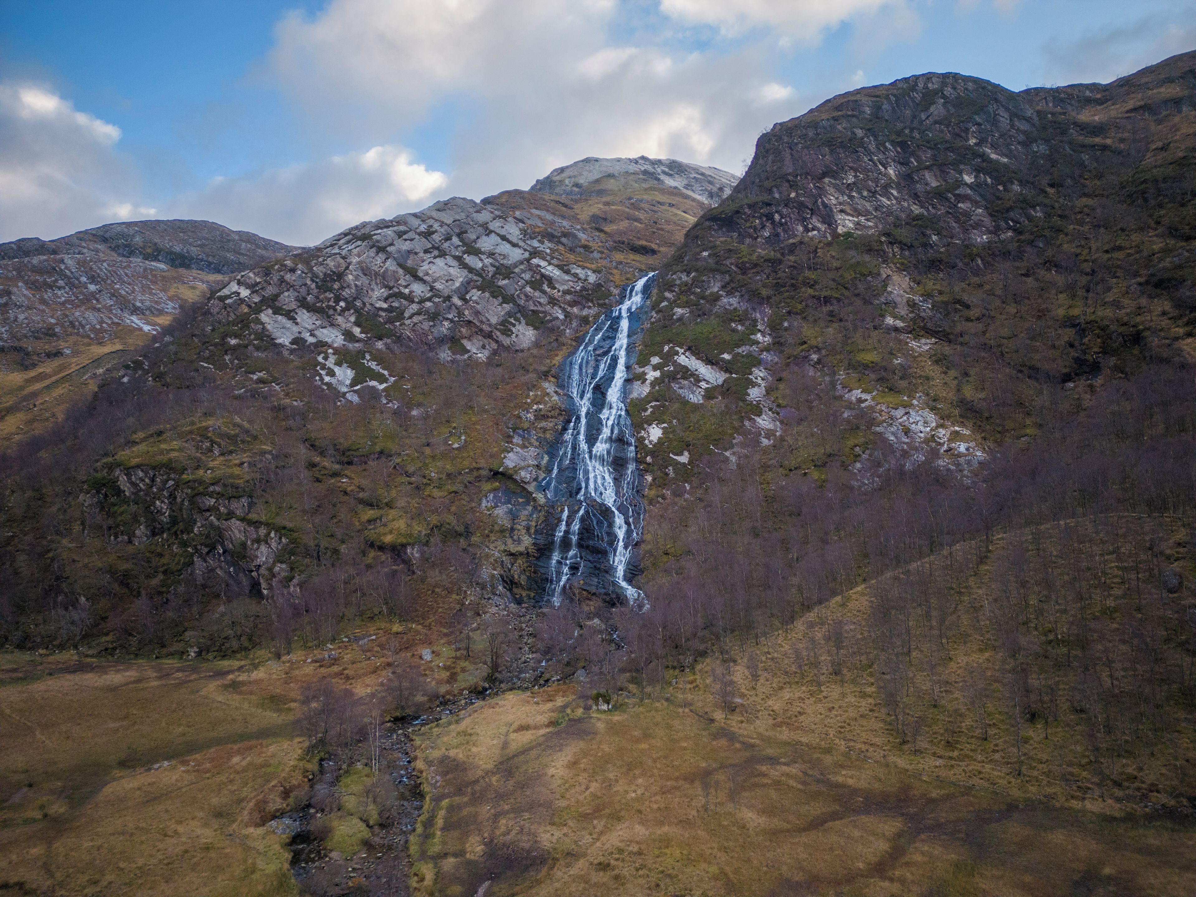 A mountainous landscape with a waterfall.