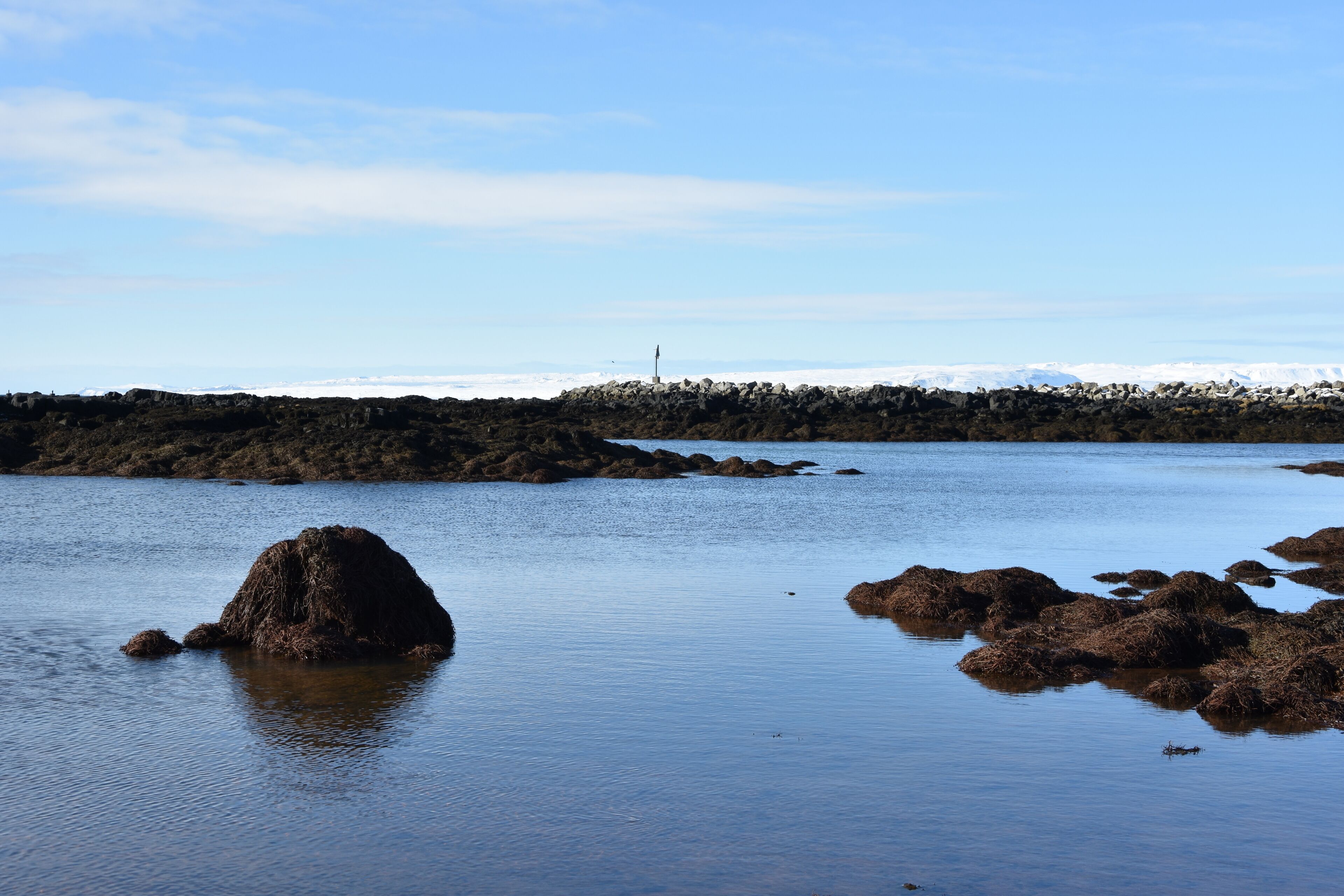 A rocky shoreline with a clear sky.