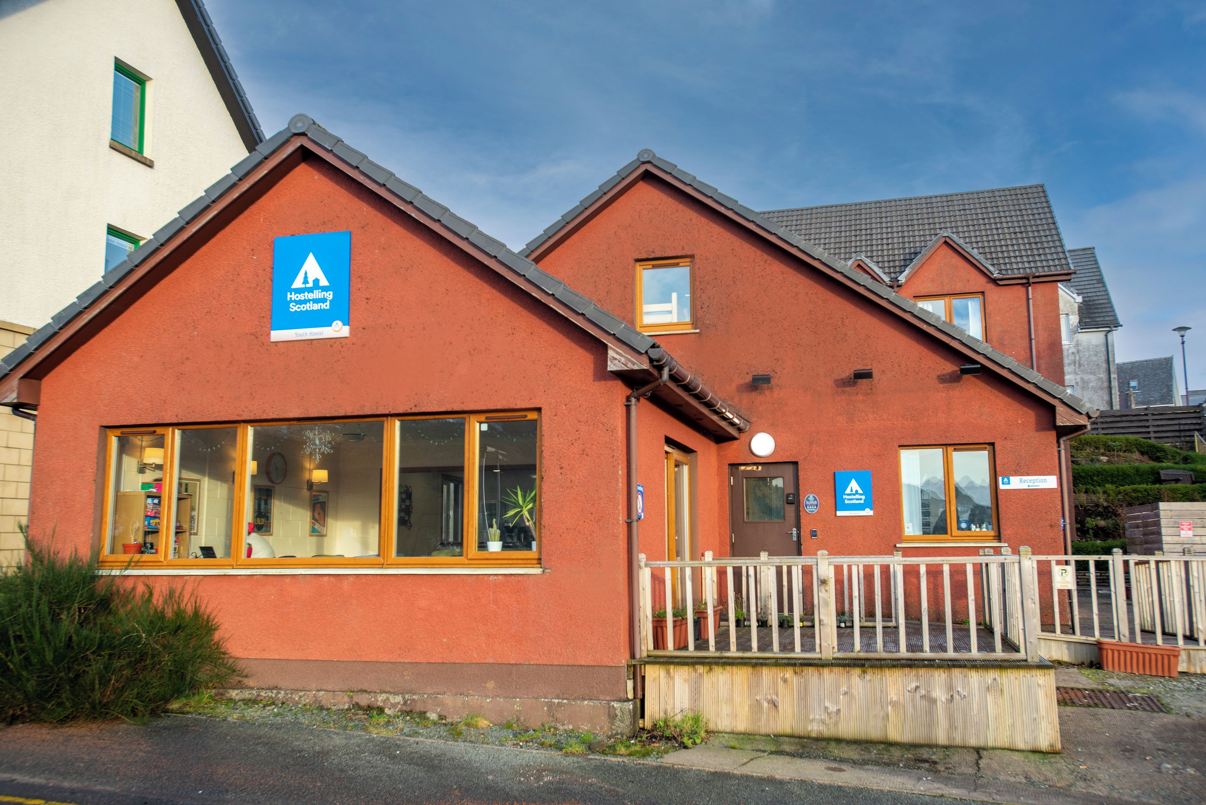 A hostel with a reception area, a Youth Hostel sign, and a reception sign.