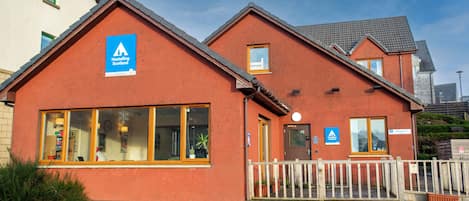Une auberge de jeunesse dotée d’un espace d’accueil, d’une enseigne indiquant qu’il s’agit d’une auberge de jeunesse et d’une enseigne pour la réception.