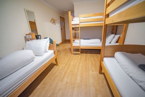A dormitory room with bunk beds, a desk with a chair, and a mirror on the wall. - Portree Youth Hostel (Portree)