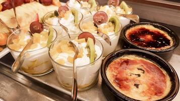 Una bandeja de postres con diversas opciones, entre ellas postres con fruta y una crème brûlée.