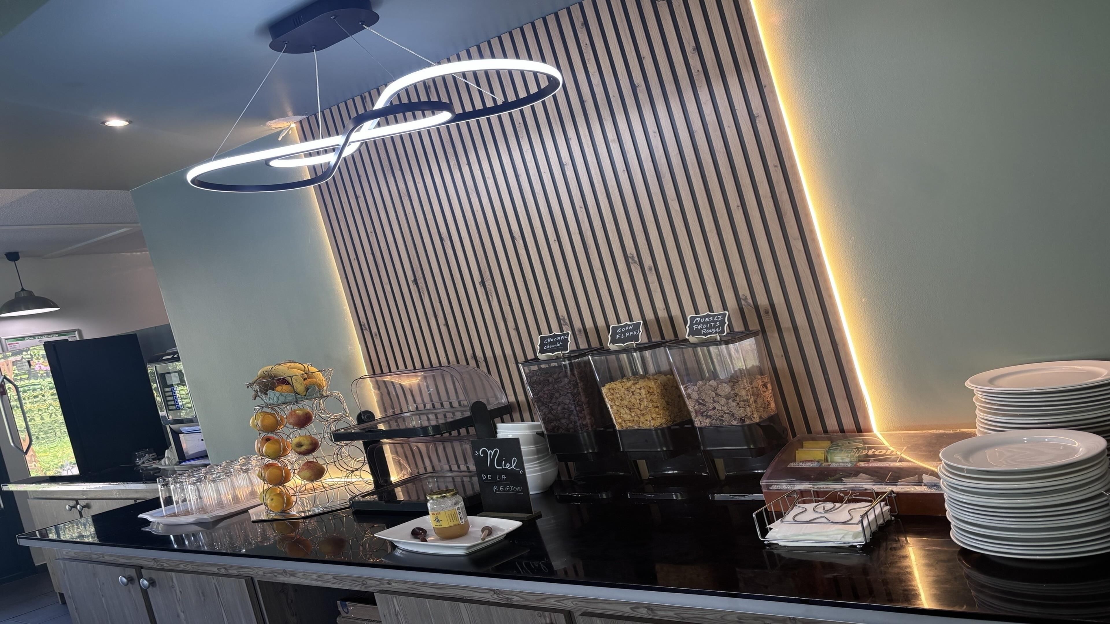 A breakfast bar with a variety of food items and a sign indicating 'Miel de la Region'.