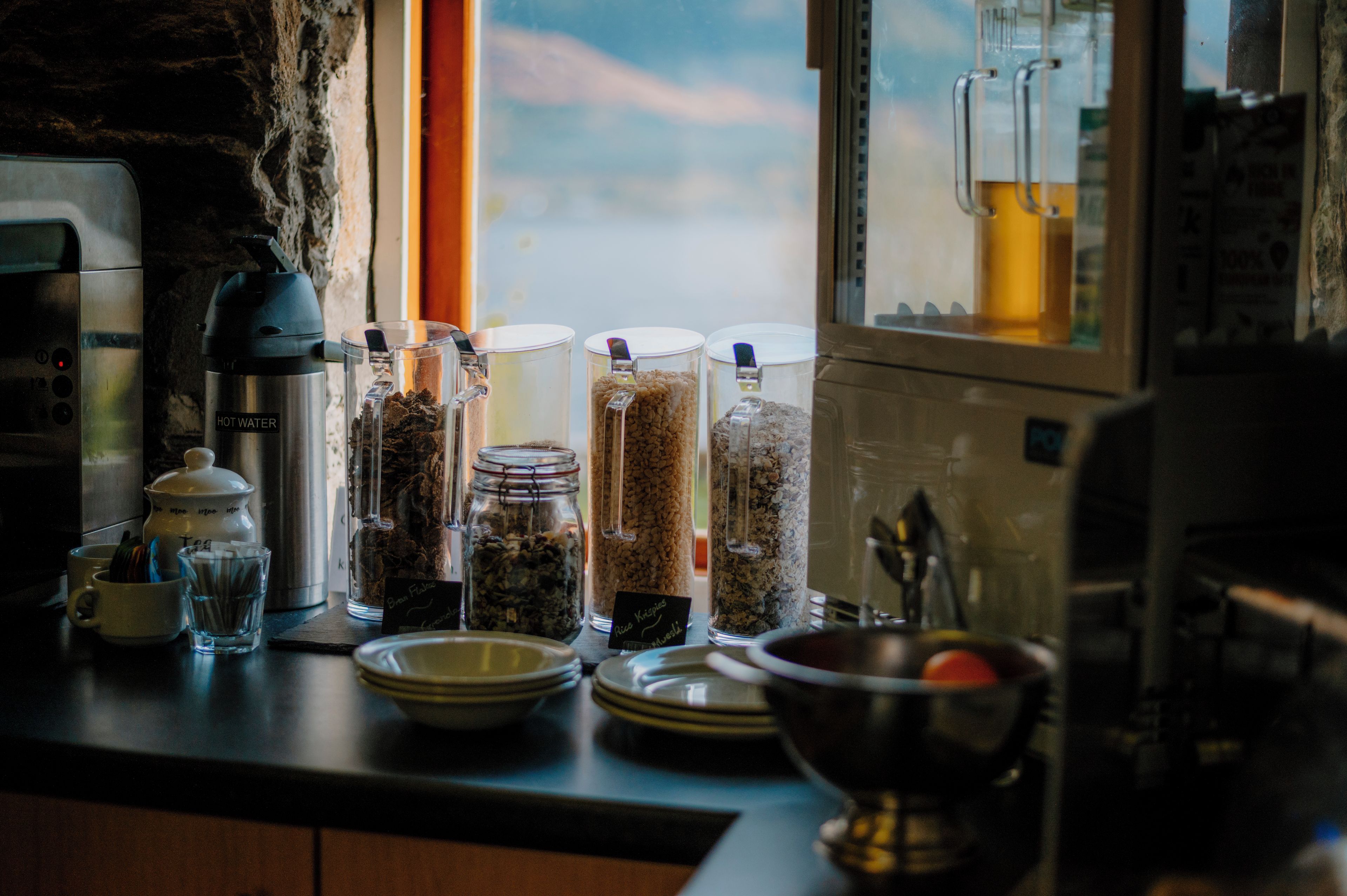 A kitchen counter with various containers of food items and a coffee maker.