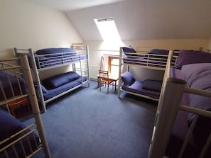 A dormitory room with bunk beds, a desk, and a chair. - Ratagan Youth Hostel (Kyle)