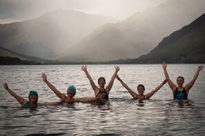 A group of people in a lake with mountains in the background. - Ratagan Youth Hostel (Kyle)