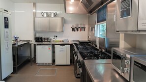 A commercial kitchen with stainless steel appliances, including a refrigerator, dishwasher, and stove. - Glenbrittle Youth Hostel (Minginish)