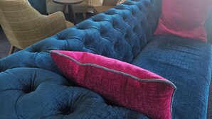 A cozy living room with a blue sofa, a small round table, and a chair. - Kirkwall Youth Hostel (Kirkwall)