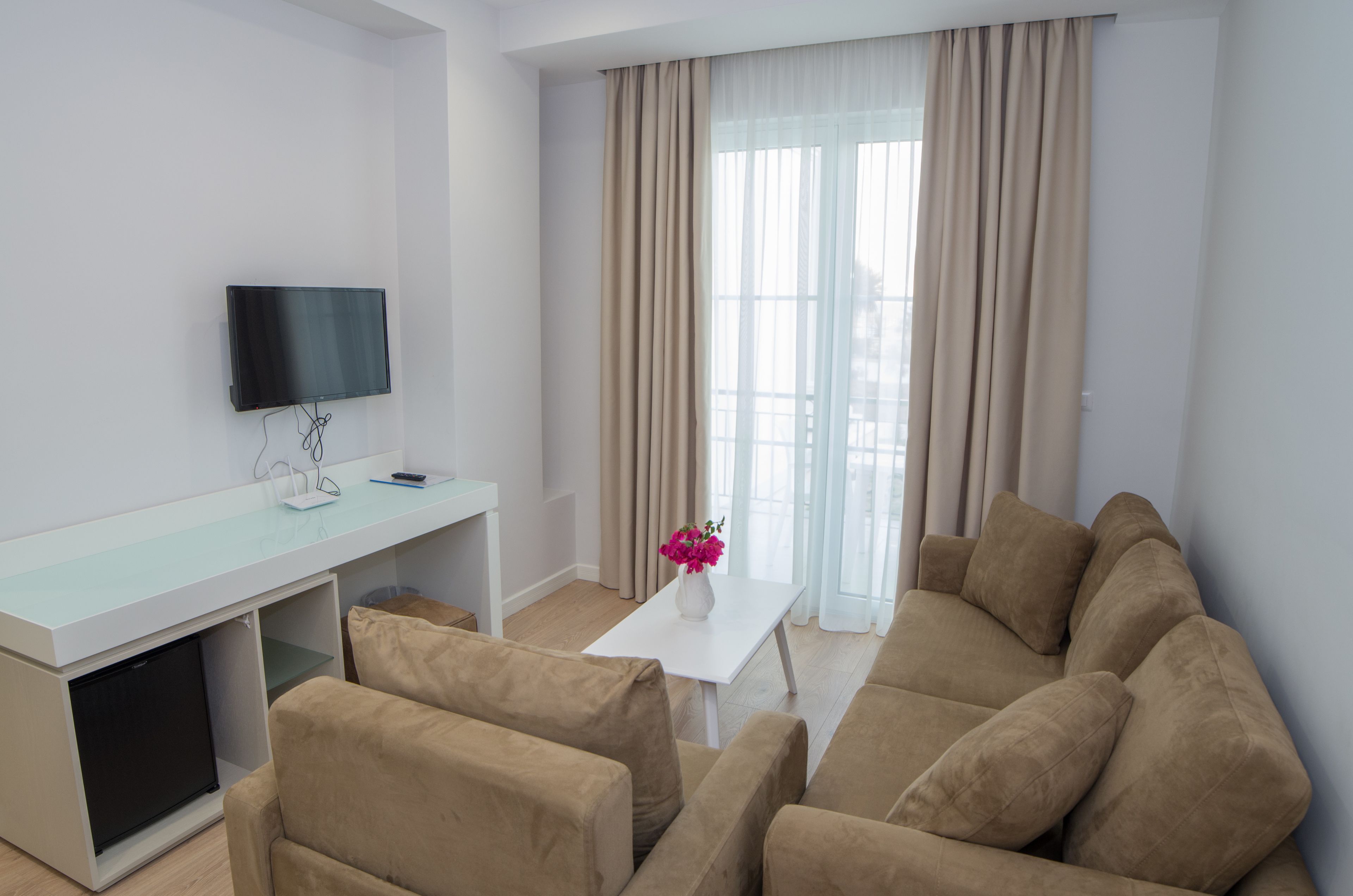 quadruple room, partial sea view | living room | flat-screen tv