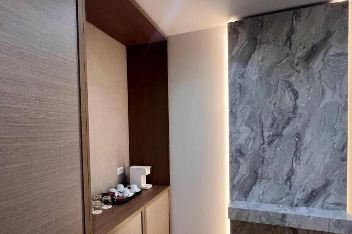Uma cozinha moderna com armários de madeira, painel de parede de mármore e piso em padrão herringbone.