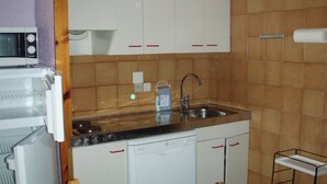 A compact kitchen with white cabinets, a stainless steel sink, a microwave, and a dishwasher. - LCB Apartaments Pie de Pistas (Pas de la Casa)