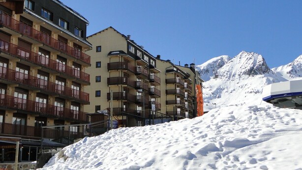 A multi-story hotel with balconies and a snowy mountain backdrop. - LCB Apartaments Pie de Pistas (Pas de la Casa)