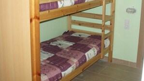 A bunk bed with two levels, each with a purple and white patterned mattress. The room has light green walls and a tiled floor. - LCB Apartaments Pie de Pistas (Pas de la Casa)