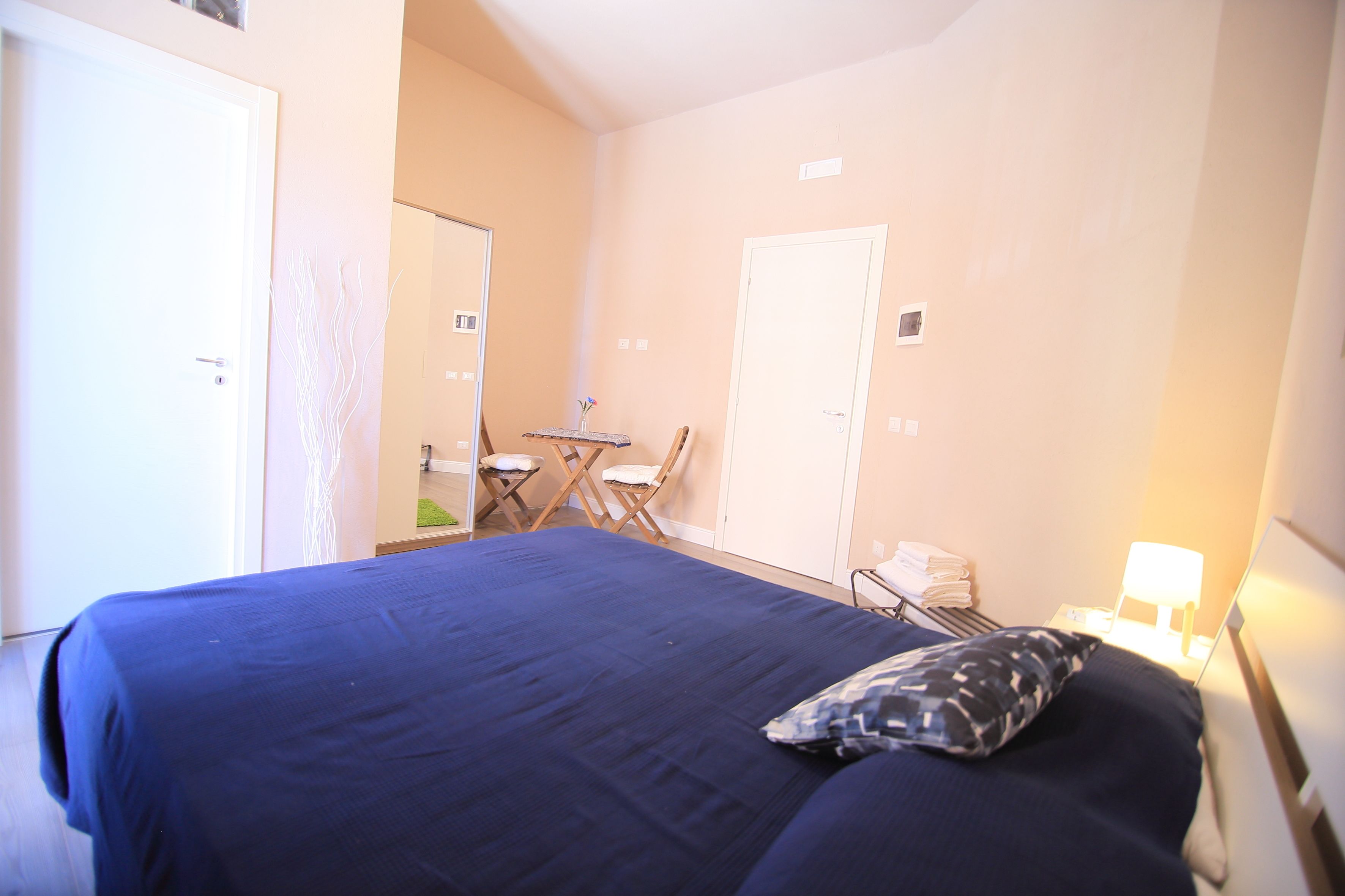 A hotel room with a bed, a desk, and a chair.