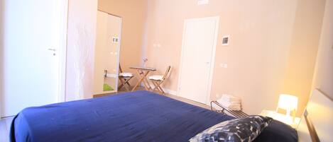 A hotel room with a bed, a desk, and a chair.