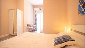 A hotel room with a bed, a wardrobe, a desk, and a chair.