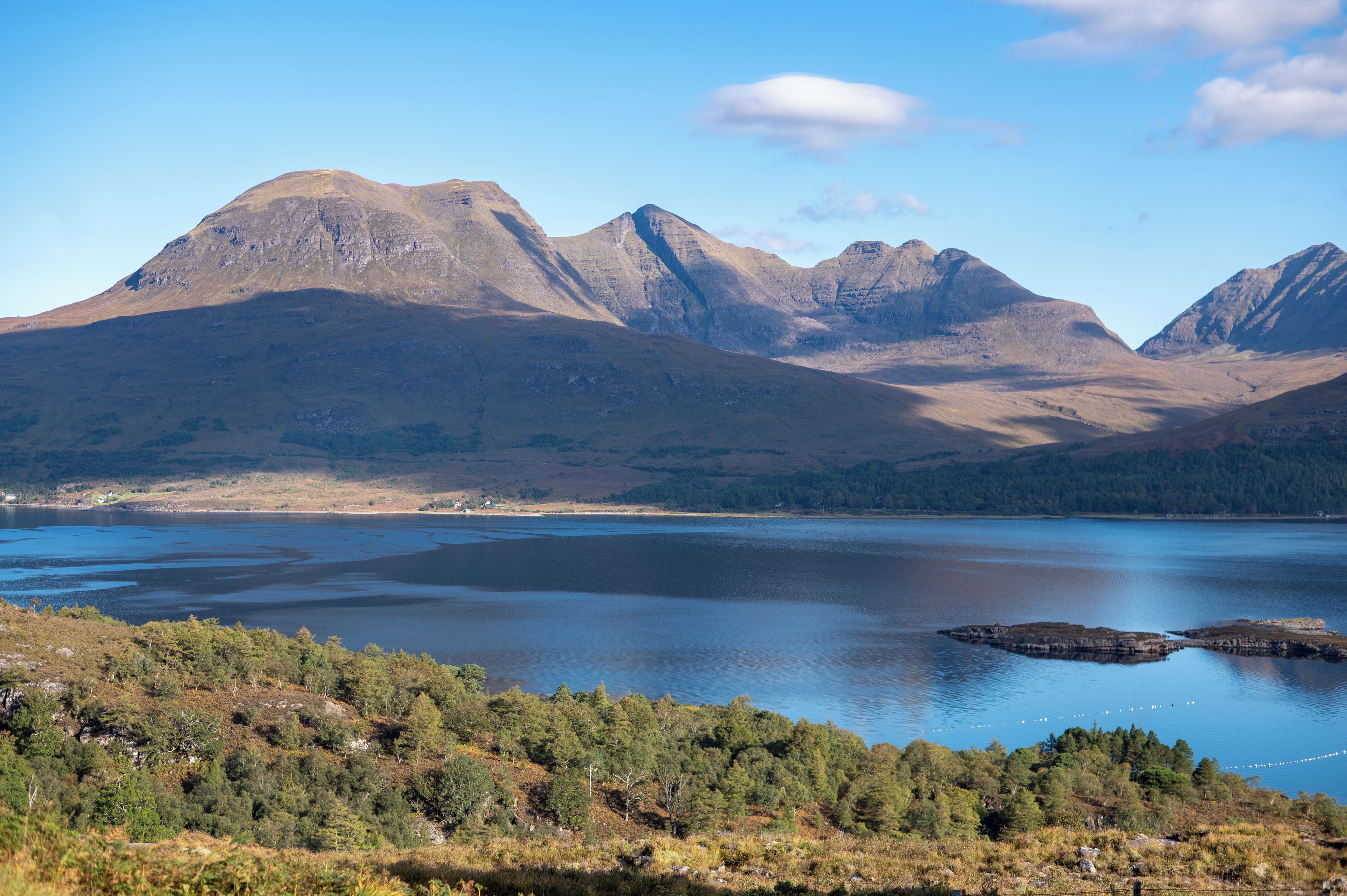 Un paisaje montañoso con un lago y una zona boscosa.