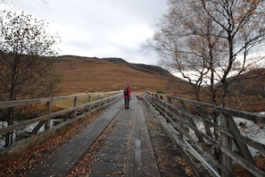 A wooden bridge with a person and a dog on it. - Torridon Youth Hostel (Achnasheen)
