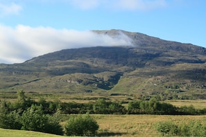 A mountainous landscape with a valley and a mountain peak partially obscured by clouds. - Torridon Youth Hostel (Achnasheen)