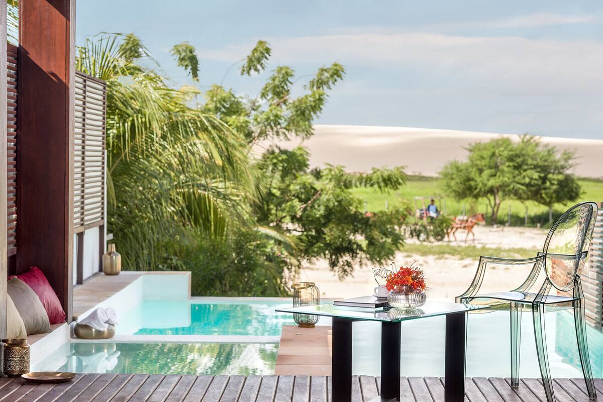 Una mesa de vidrio con vistas a una piscina y al paisaje desértico.