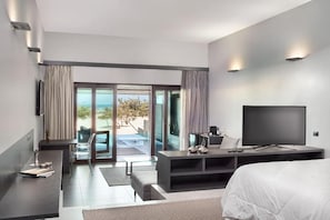 A modern hotel room with a bed, a TV, a desk, and a balcony with a view. - Essenza Dune (Jijoca de Jericoacoara)