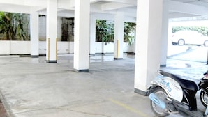 An indoor parking area with white pillars and a concrete floor. - The Kiri Resitel (Phetchaburi)