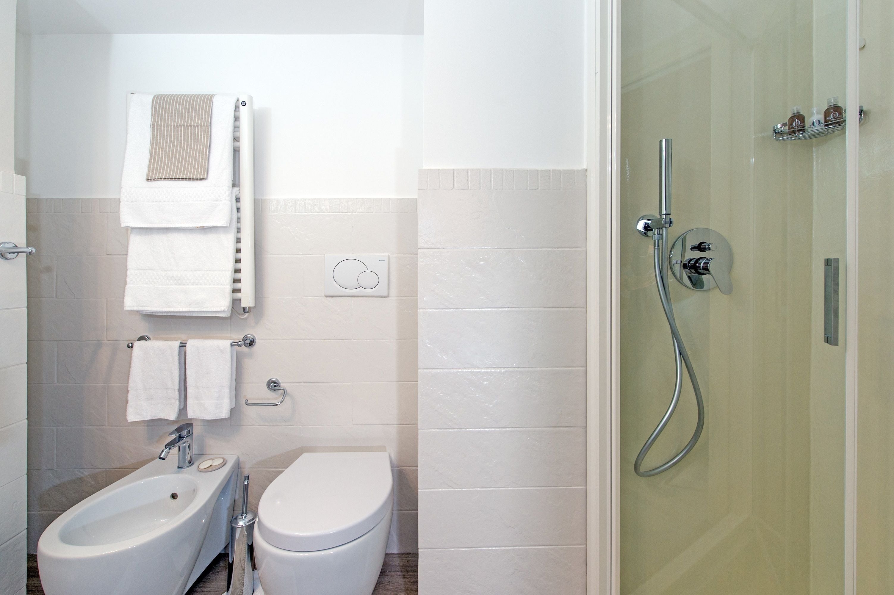 Un baño moderno con bidé, inodoro y ducha.