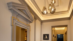 A hallway with a bench, a framed mirror, and a letter 'A' on the wall. - Avenue Legerova 19 (Prague)
