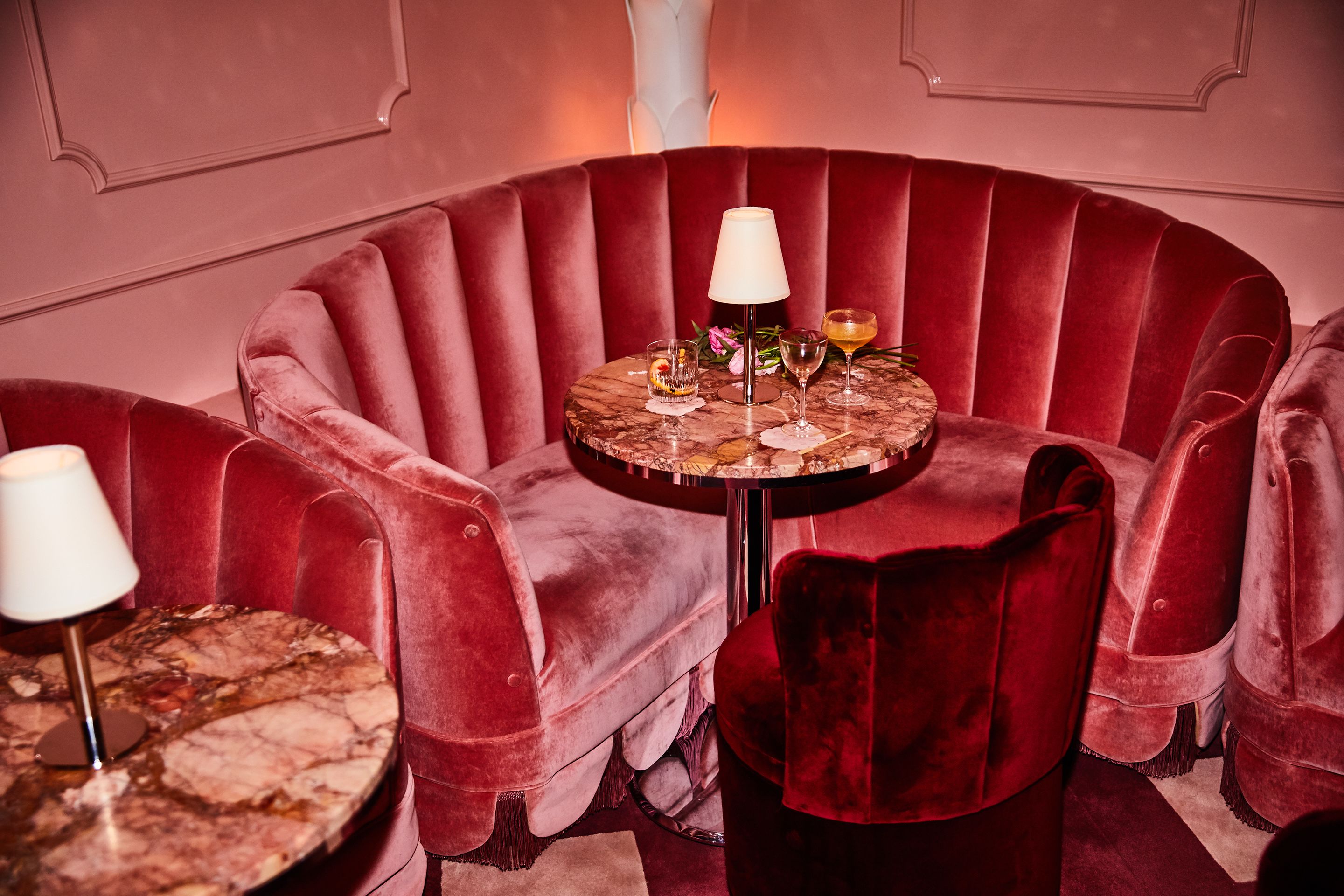 A corner seating area with a round table, two chairs, and a lamp.