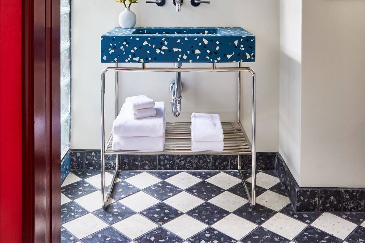 A bathroom with a mirror, sink, and towel rack.