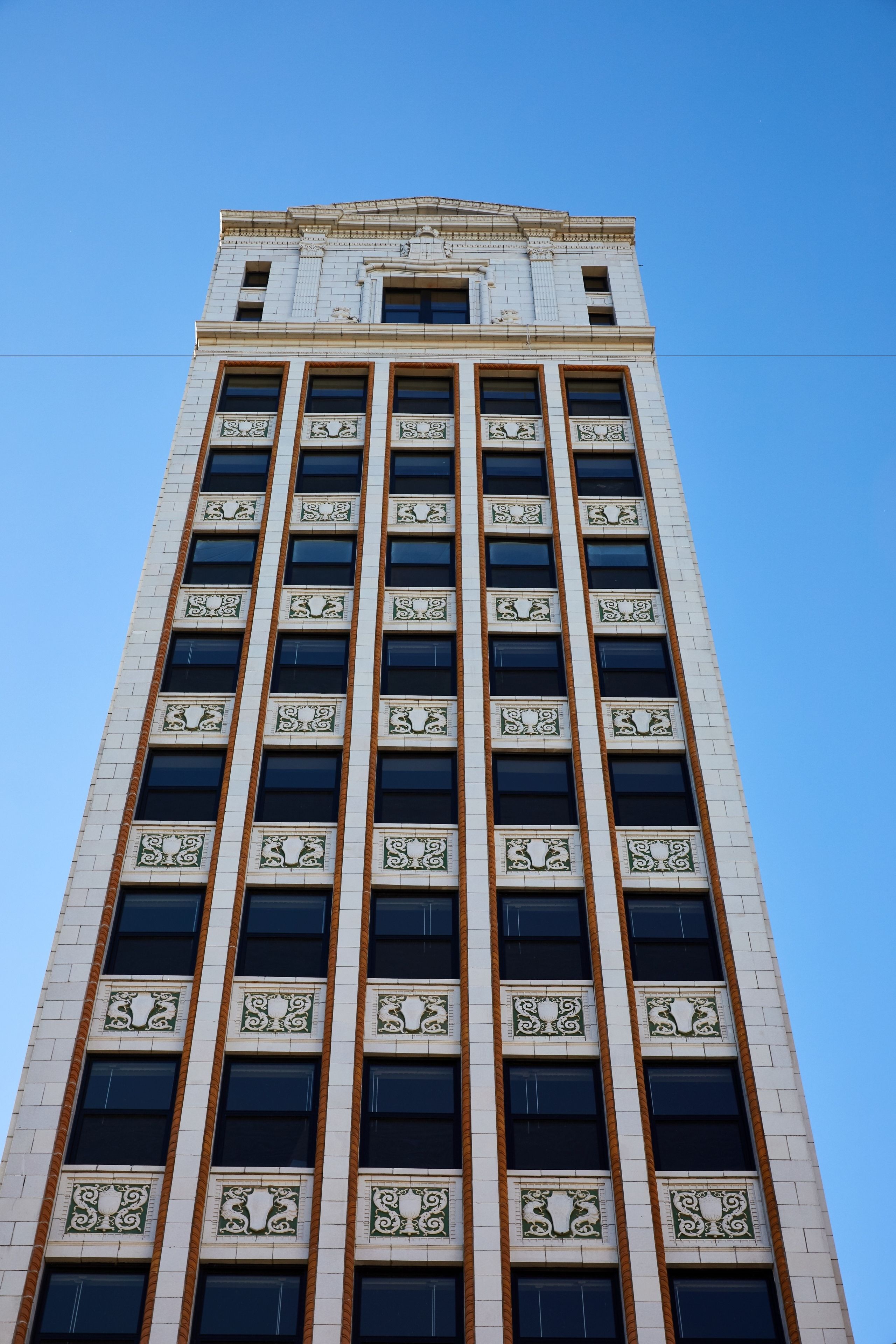 Un edificio alto con facciata simmetrica, ampie finestre e modanature decorative.