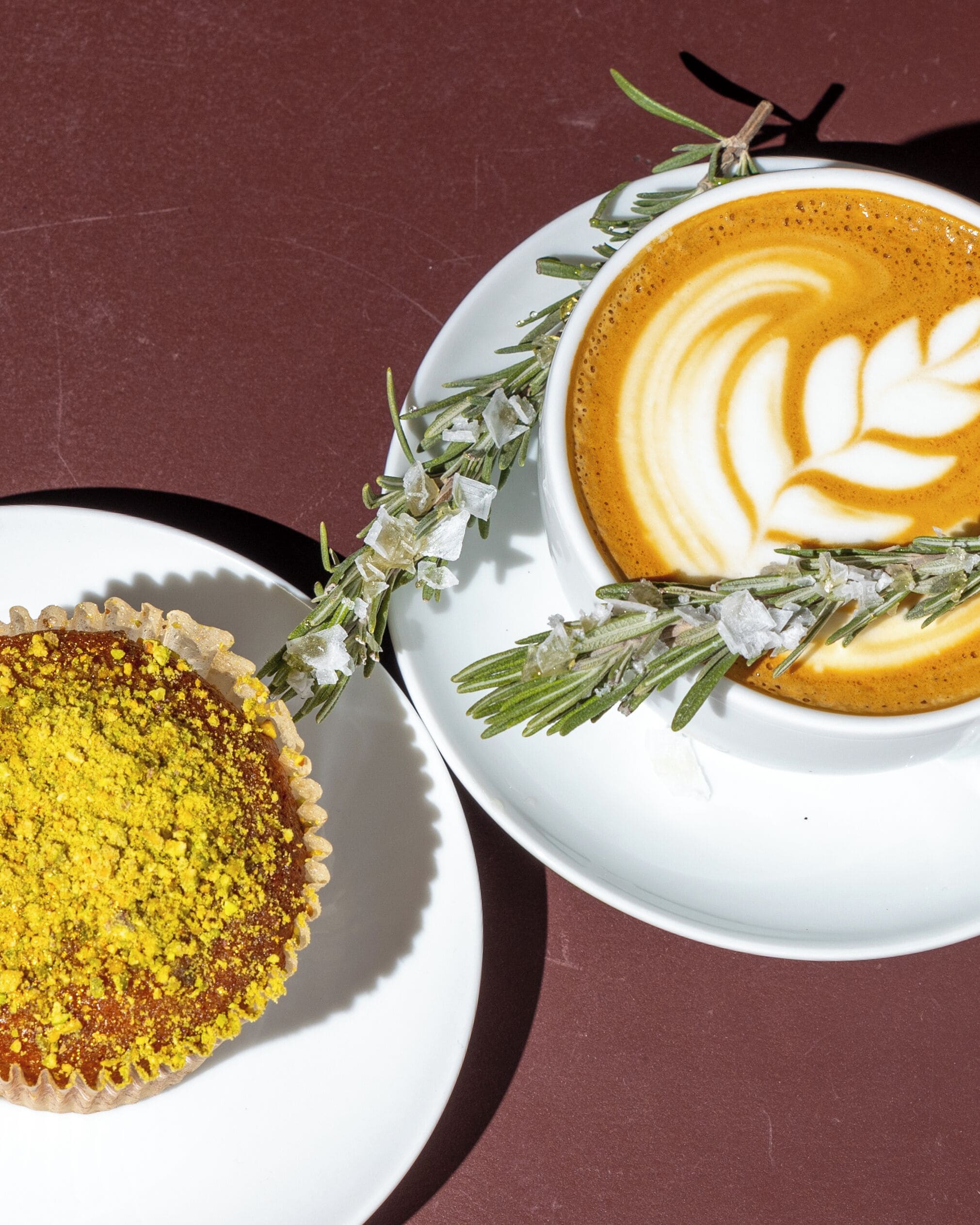 A dessert with a golden crust and a white plate with a latte art design.