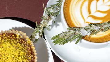 A dessert with a golden crust and a white plate with a latte art design.