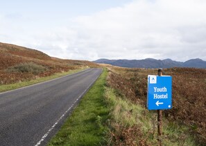 A road with a sign indicating a Youth Hostel to the left. - Gairloch Sands Youth Hostel (Gairloch)