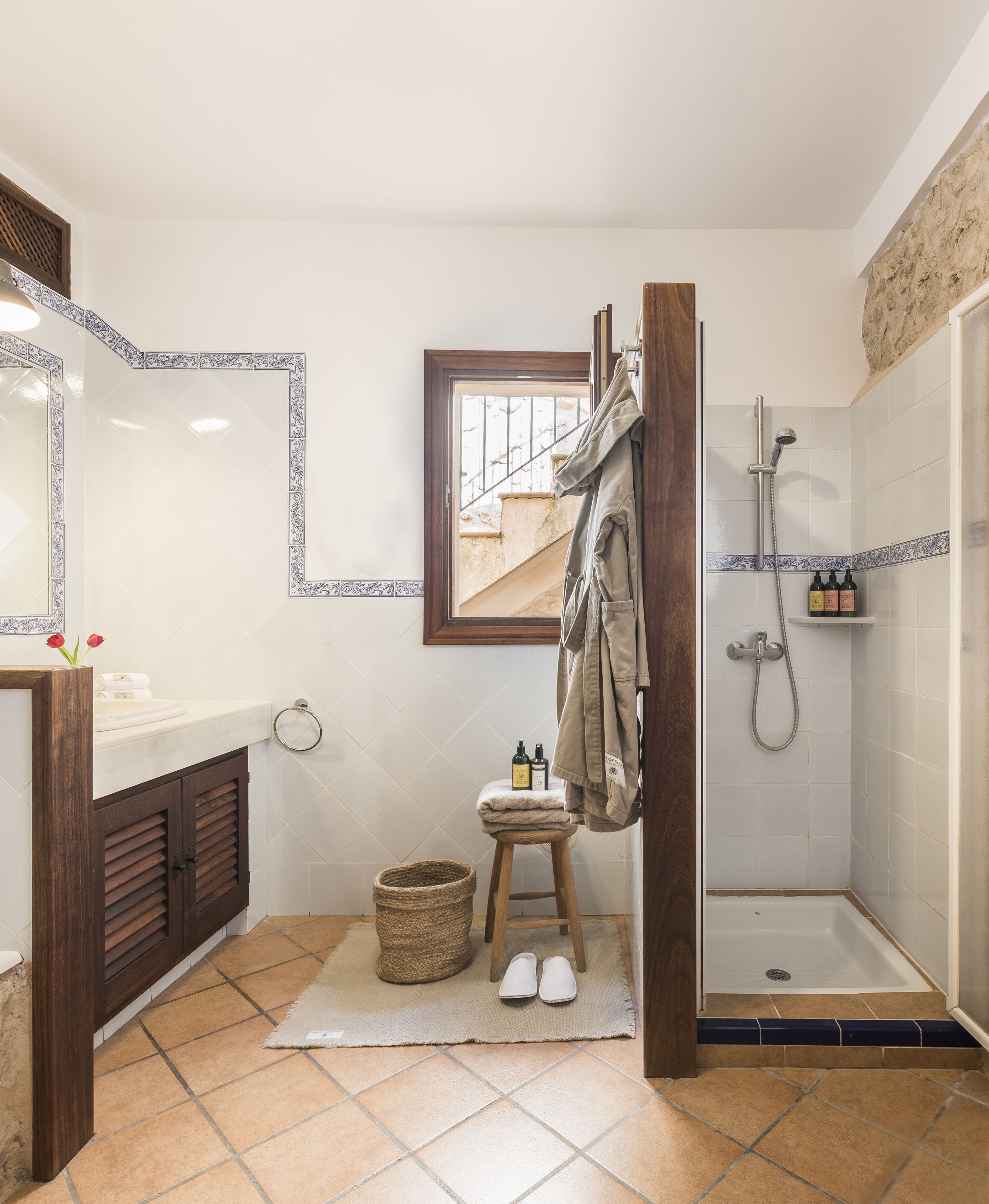 A bathroom with a shower, a sink, a mirror, and a towel rack.