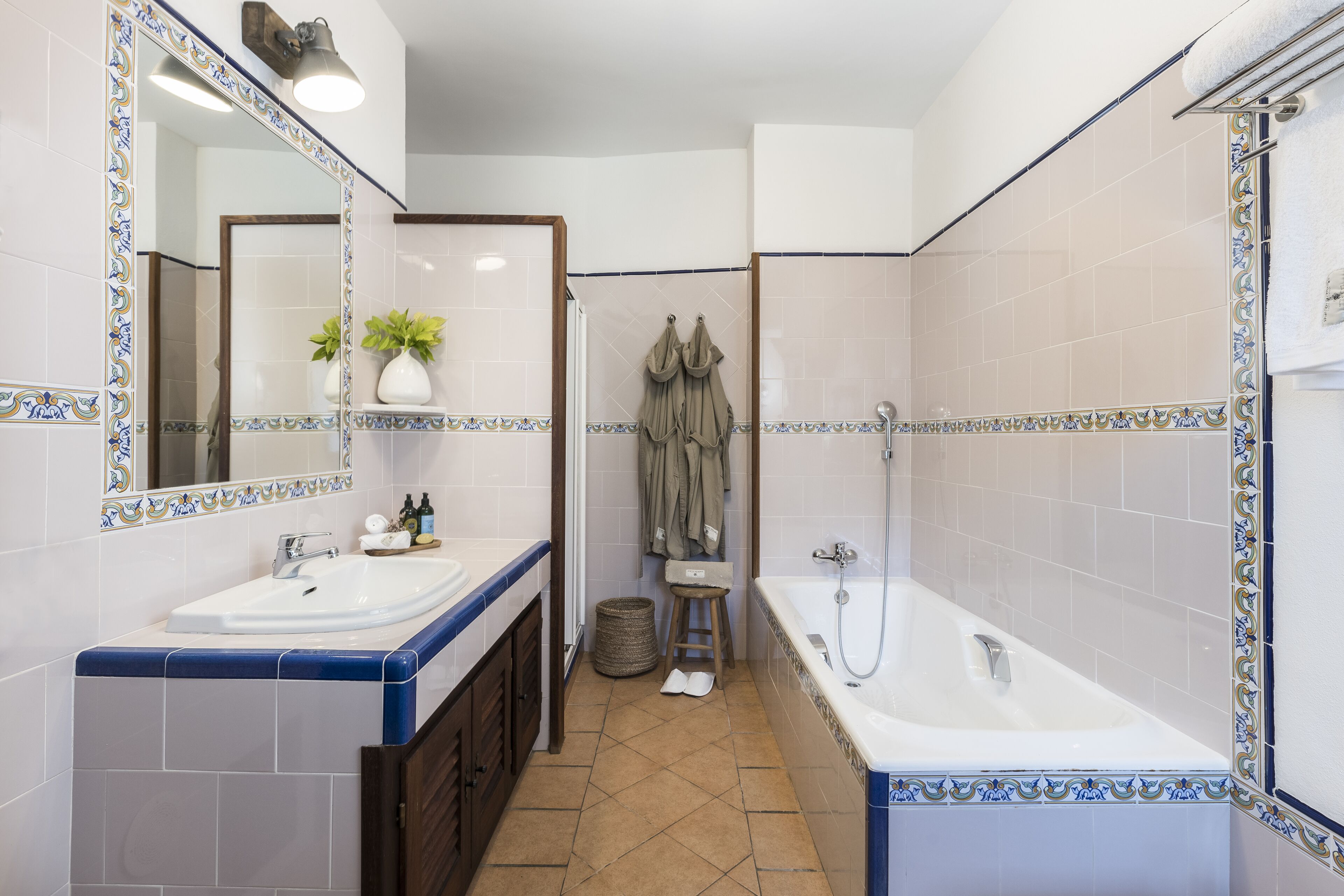 A bathroom with two sinks, a bathtub, and a mirror.