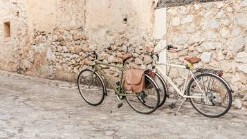 Dos bicicletas estacionadas frente a una pared de piedra.