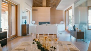 A dining table set with wine glasses, plates, and cutlery, with a vase of flowers in the center. -  Finca Can Beneït (Selva)