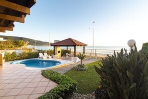 Una piscina al aire libre, sillones reclinables de piscina