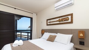 Una habitación de hotel con cama, vista al mar y una obra de arte de madera en la pared.