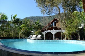 Una piscina al aire libre, sillones reclinables de piscina