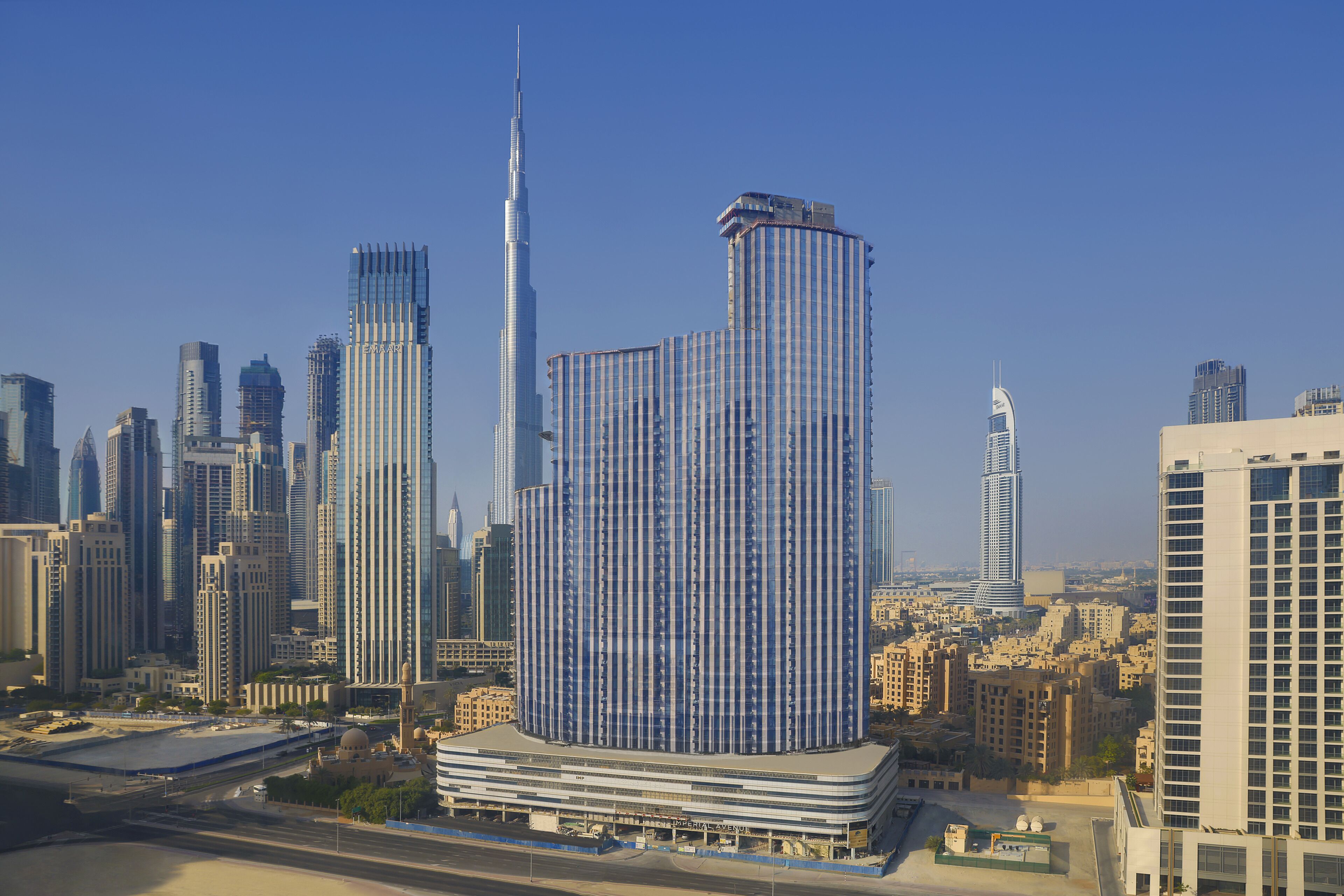A high-rise building with a unique curved design, surrounded by other tall buildings in a cityscape.