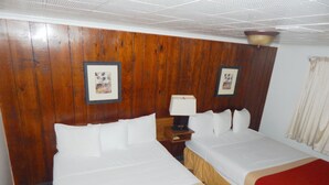 Een hotelkamer met twee bedden, houten paneelwanden en beeldeijkaders.